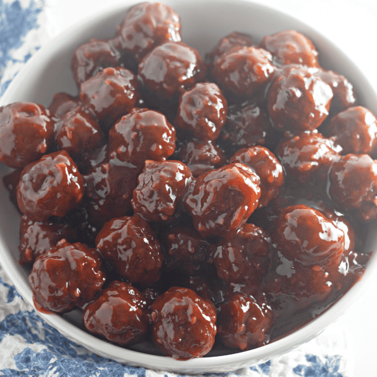 Chili sauce and cranberry sauce meatballs in a slow cooker with toothpicks