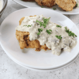 Denny's copycat country fried steak and eggs with country gravy, hash browns, and toast on a white diner plate