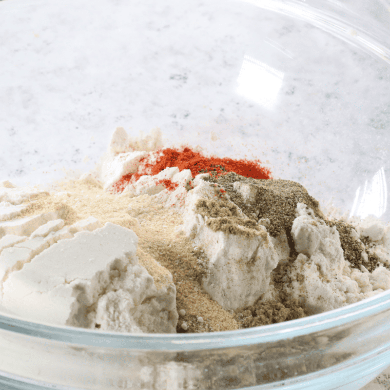 Seasoned flour and buttermilk egg wash in two shallow dishes for breading country fried steak