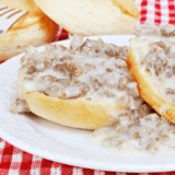 Denny's sausage gravy and biscuits copycat with creamy peppery gravy ladled over split buttermilk biscuits