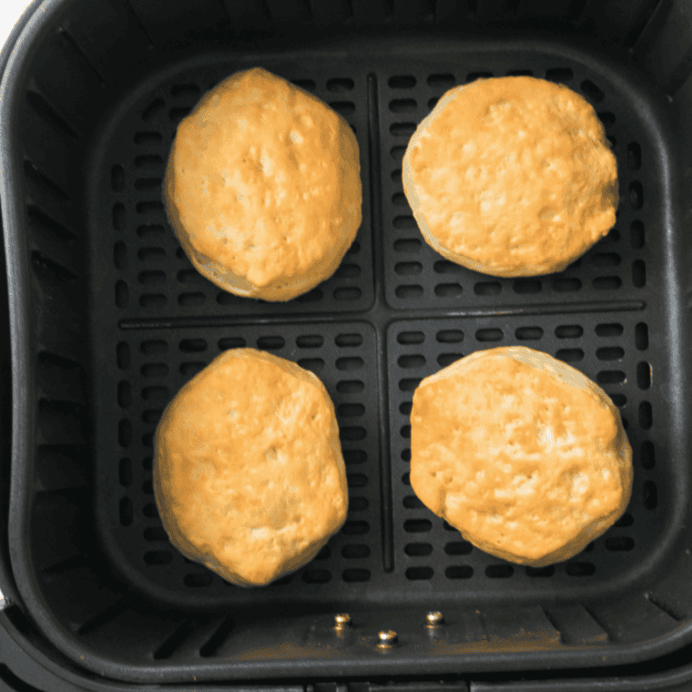 Golden cooked biscuits in an air fryer basket for Denny's sausage gravy and biscuits