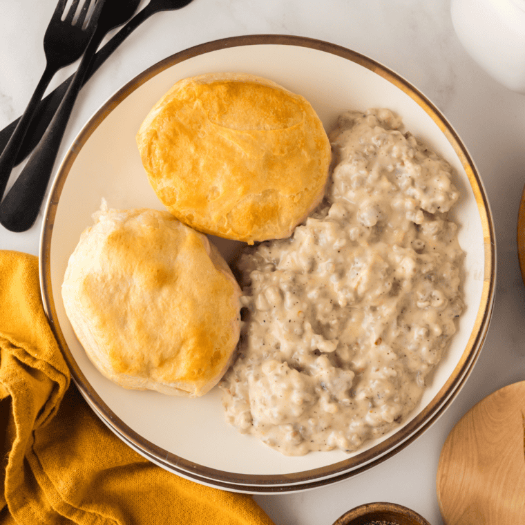 Copycat Denny's biscuits and gravy on a plate with crumbled sausage gravy and cracked black pepper