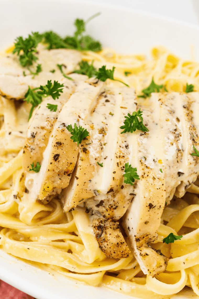 Close-up of silky Alfredo sauce clinging to fettuccine noodles in a copycat Fazoli's fettuccine Alfredo