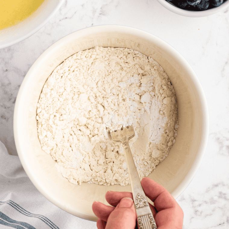 Blackberries folded into sugar, cornstarch and lemon zest in a large mixing bowl for cobbler filling