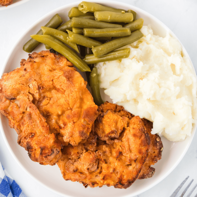 Ina Garten buttermilk fried chicken piled on a white platter with golden crispy coating