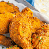 Ina Garten buttermilk fried chicken piled on a white platter with golden crispy coating