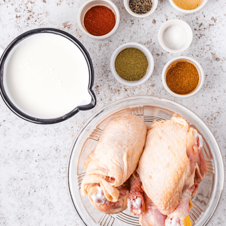 Ingredients for buttermilk fried chicken including chicken pieces, buttermilk, flour, salt, pepper, and paprika