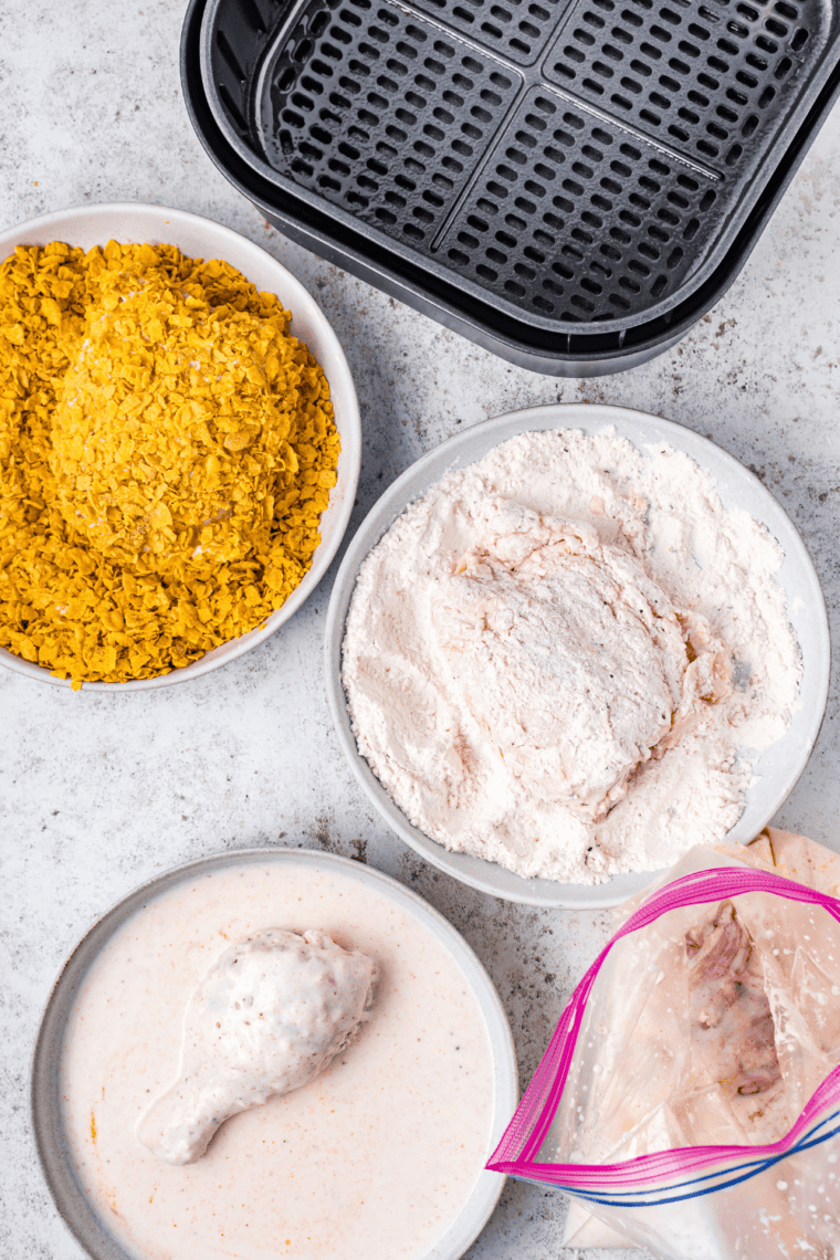 Raw chicken pieces soaking in a bowl of buttermilk seasoned with salt and pepper