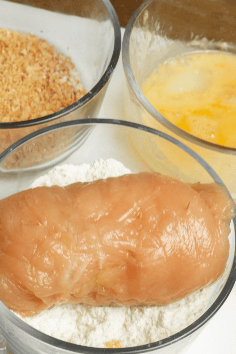 Breading station with seasoned flour, beaten eggs, and buttered panko for chicken cordon bleu