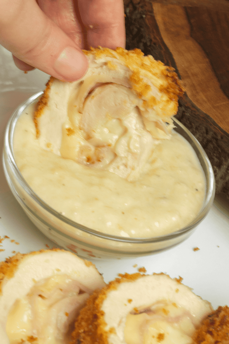Whisking Dijon cream sauce in a small saucepan for chicken cordon bleu