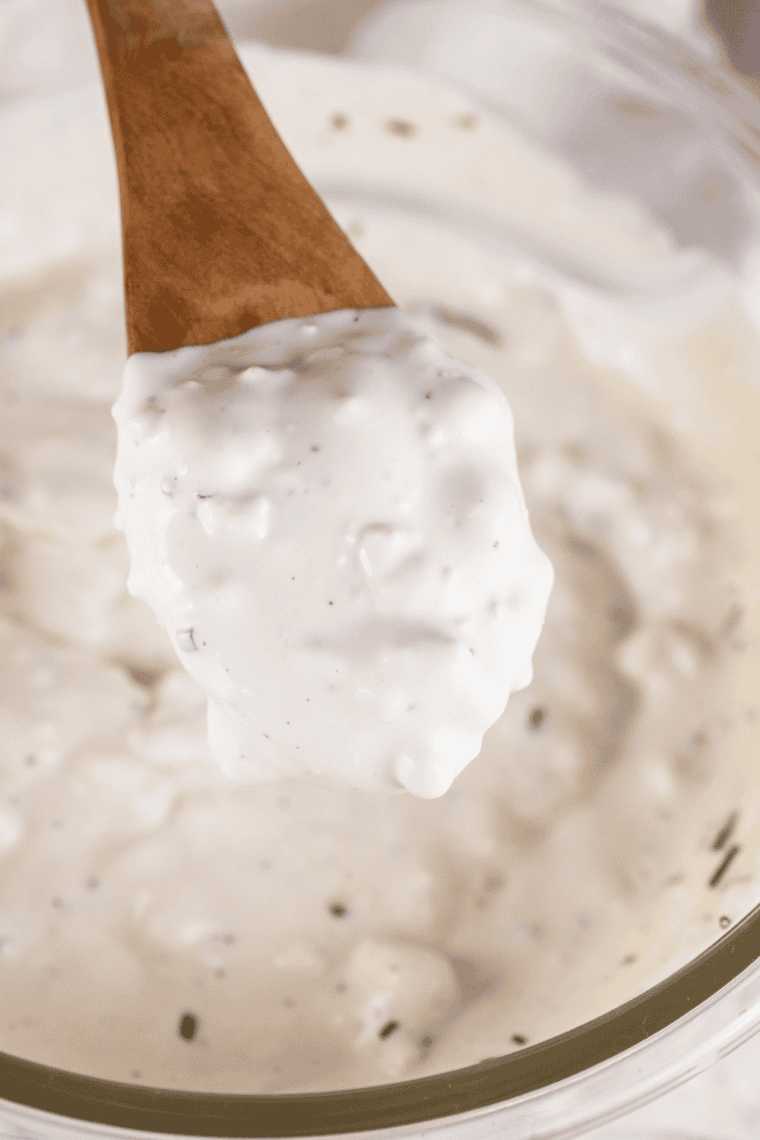 Half the blue cheese mashed with a fork in a mixing bowl