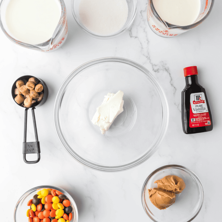 Ingredients for Ninja Creami copycat Baskin Robbins Reese's Peanut Butter Cup ice cream including milk, heavy cream, sugar, cream cheese, peanut butter, cocoa powder, vanilla, salt, and chopped Reese's cups