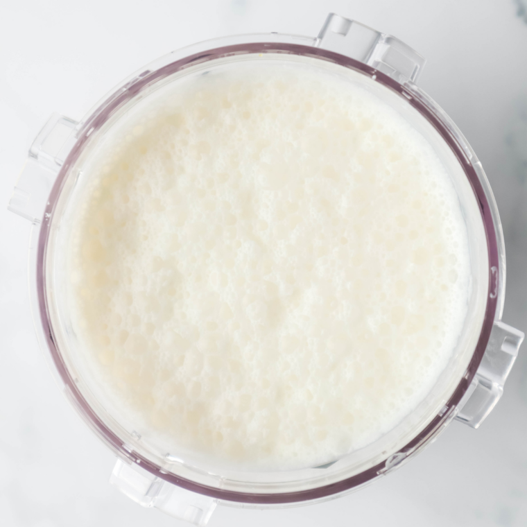 Vanilla ice cream base poured into a Ninja Creami pint before freezing