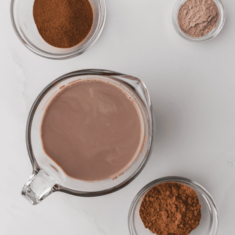 Ingredients for Ninja Creami World Class Chocolate ice cream including heavy cream, whole milk, sugar, cocoa powder, milk chocolate chips, white chocolate chips, cream cheese, and vanilla