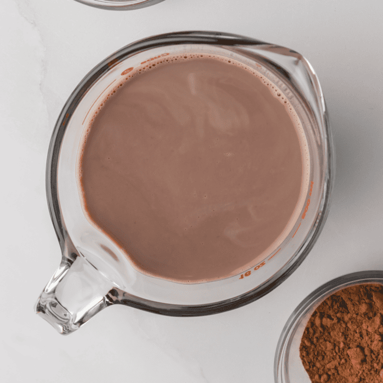 Whisking heavy cream, milk, sugar, cocoa powder, and melted milk chocolate into a smooth ice cream base