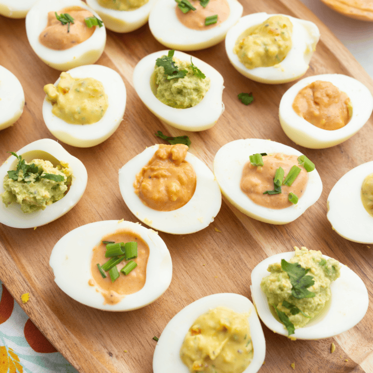 Piping yolk filling into egg white halves with a piping bag