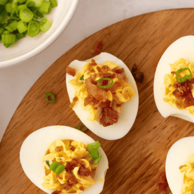 Platter of deviled eggs on a holiday table with other Southern dishes