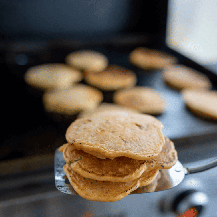 Perkins potato pancakes cooking in a full batch on a Blackstone flat top griddle