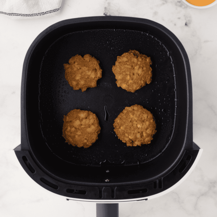 Cooked Perkins potato pancakes in the air fryer basket, browned and set on top