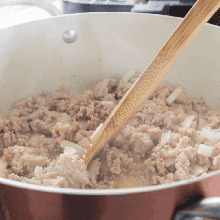 Diced onion and minced garlic cooking with browned ground beef
