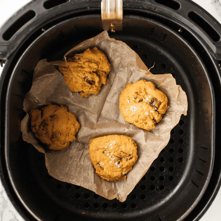 Pumpkin snickerdoodle dough balls arranged in a parchment-lined air fryer basket