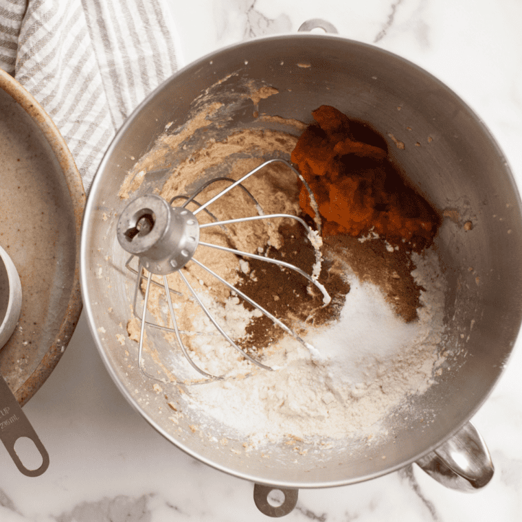 Rolling pumpkin snickerdoodle dough balls in cinnamon sugar