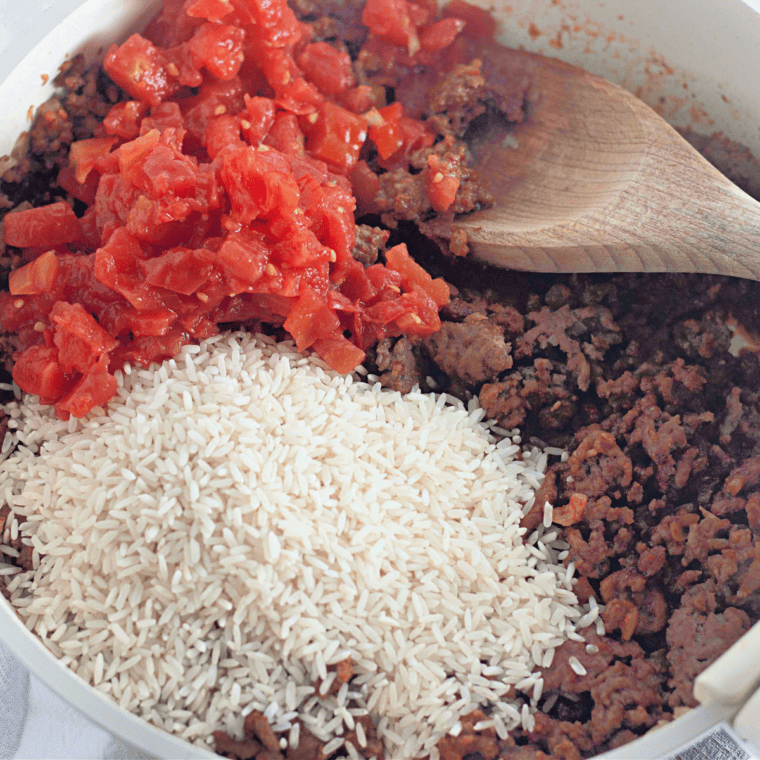 Tomato sauce, Rotel, beef broth, and uncooked rice added to taco rice skillet