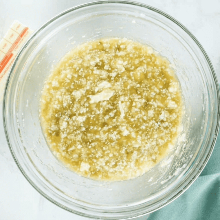 Minced garlic cooking in melted butter in a small saucepan for garlic parmesan wing sauce