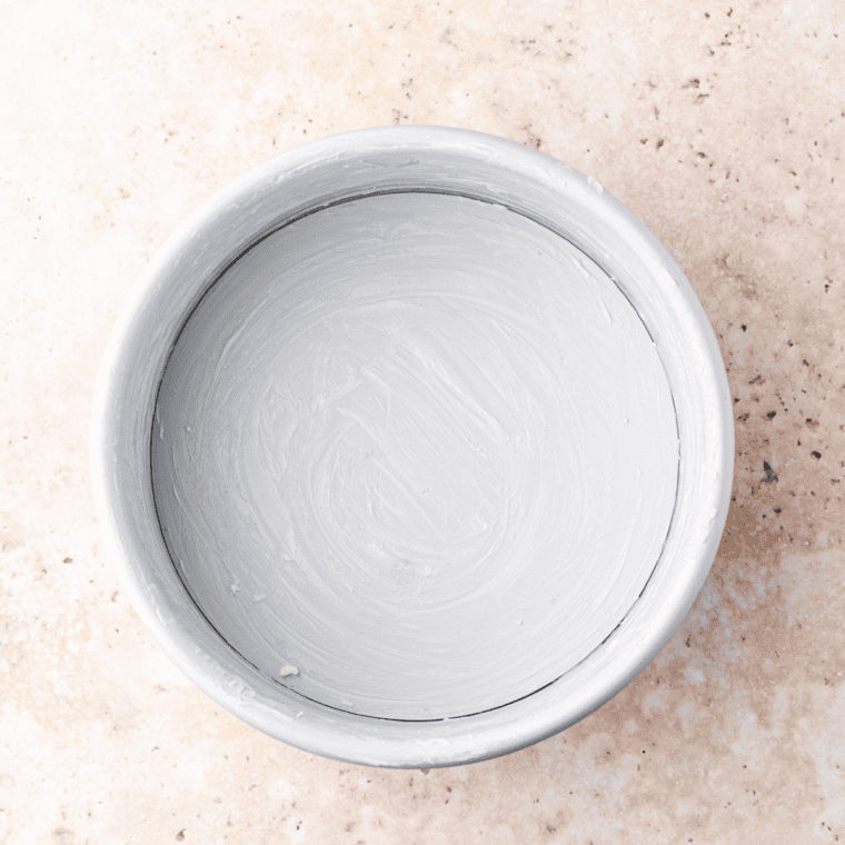 Air fryer cake pan lined with parchment paper and greased for dump cake