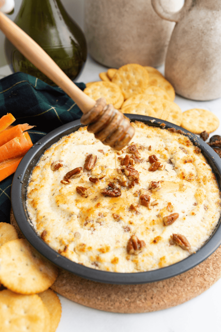 Air fryer goat cheese dip drizzled with honey and topped with chopped pecans and fresh thyme