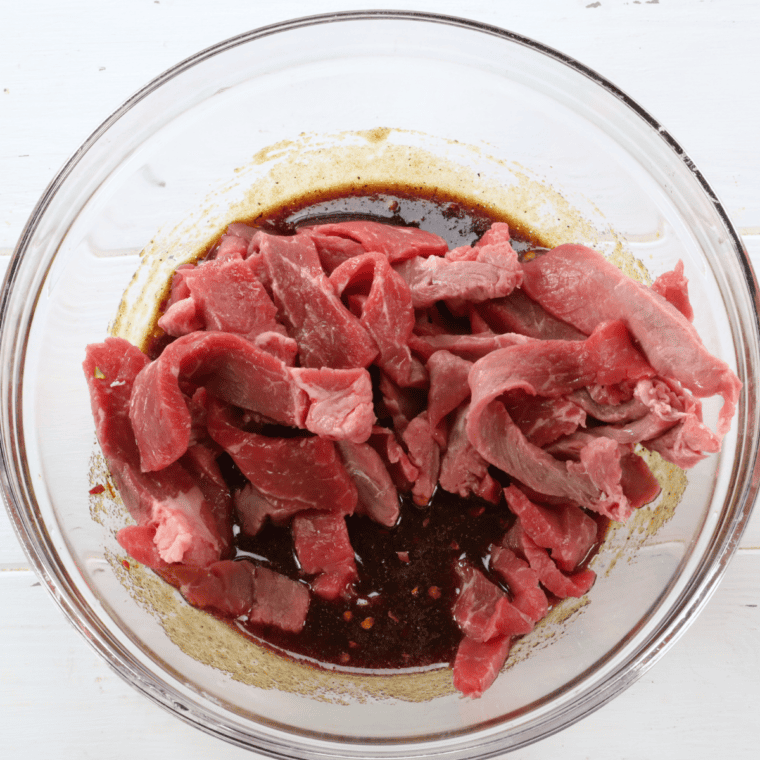 Beef strips marinating in a zip-top bag for copycat Buc-ee's jerky