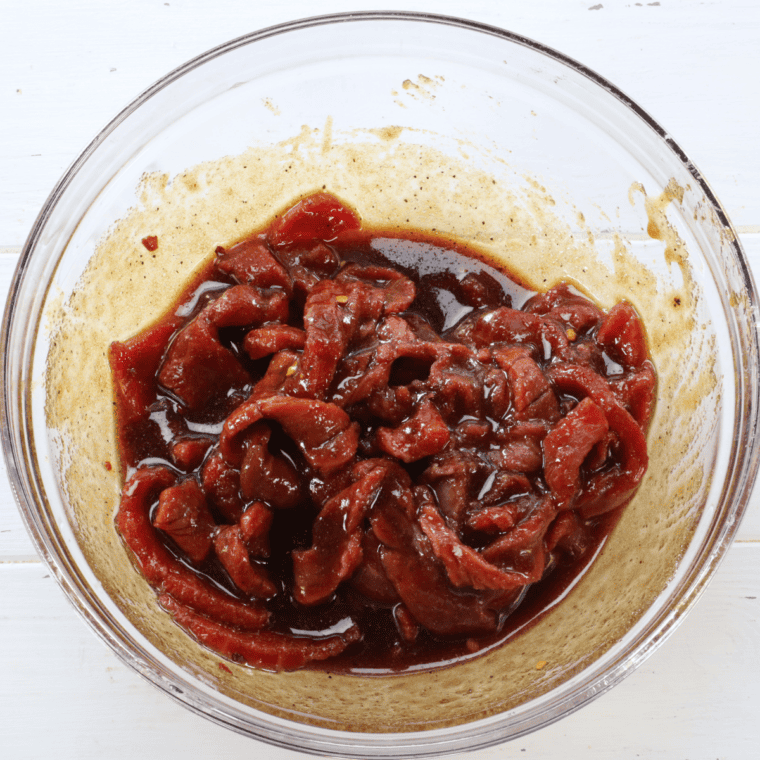 Marinated beef strips sprinkled with granulated garlic before drying
