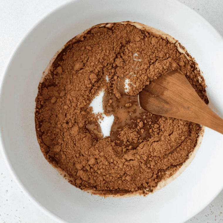 Whisking flour, sugar, salt, and baking soda in a large bowl for Coca-Cola cake