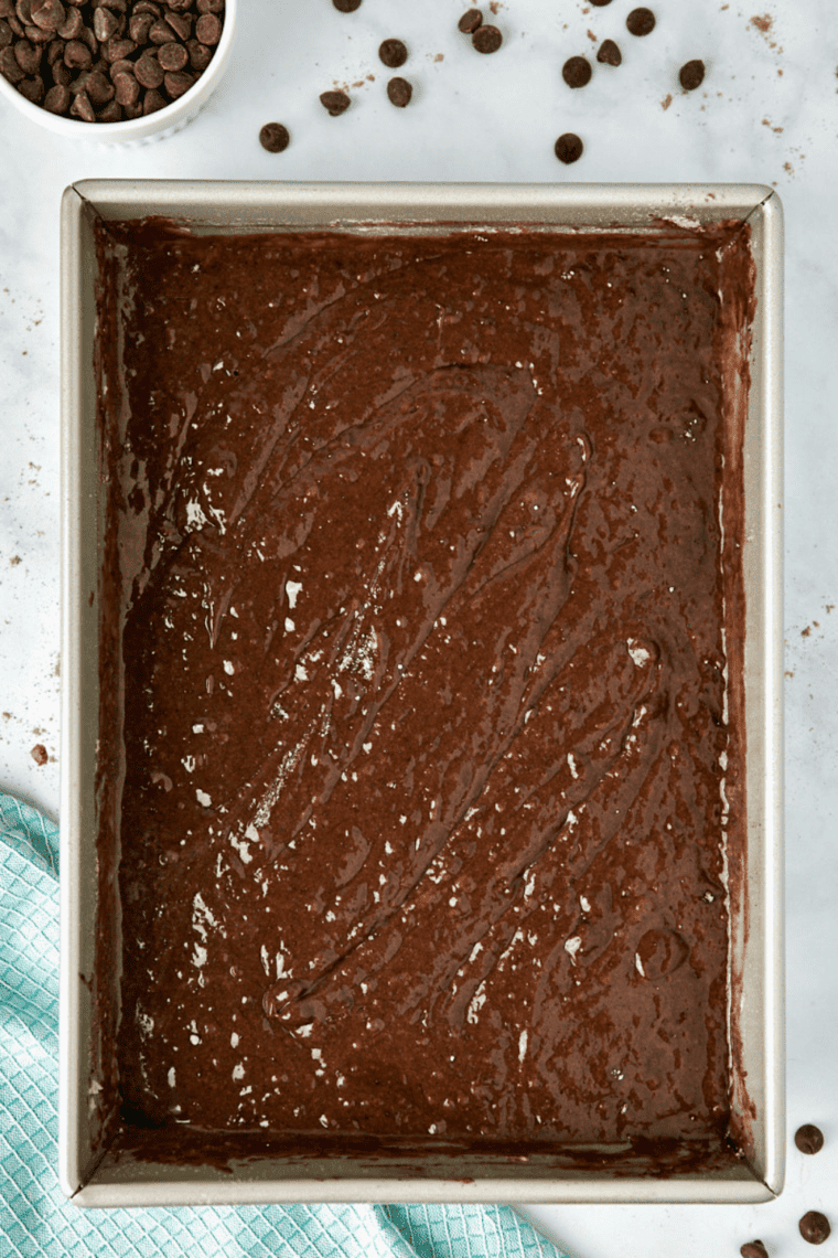 Thin Coca-Cola cake batter poured into a greased 9x13-inch baking pan