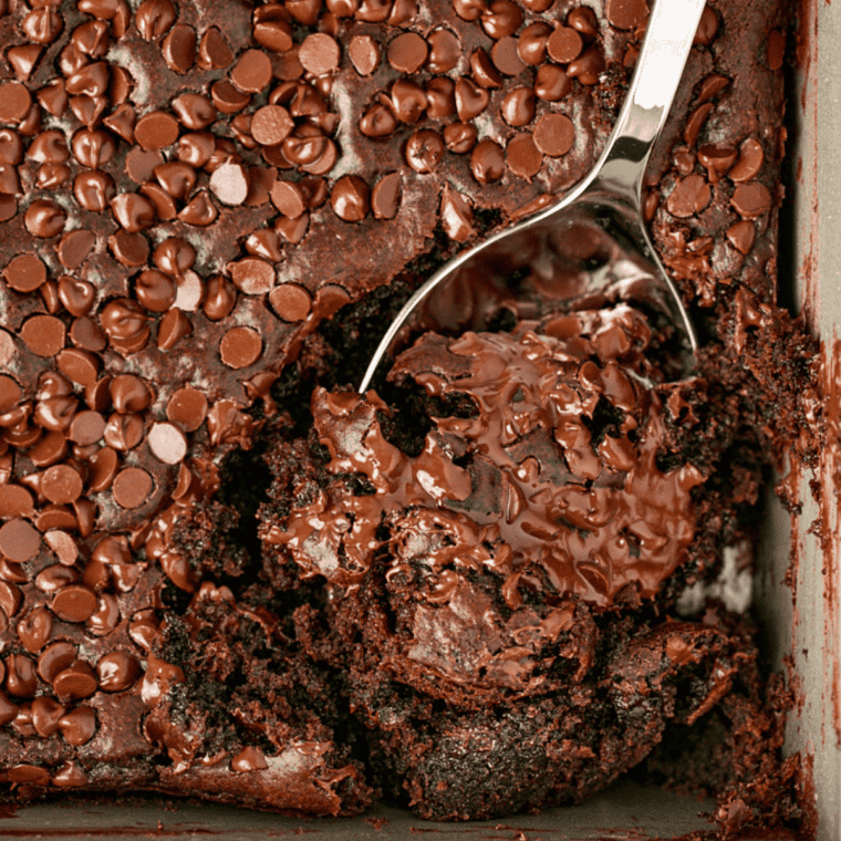 Fudgy Coca-Cola cake square on a white plate with a scoop of vanilla ice cream