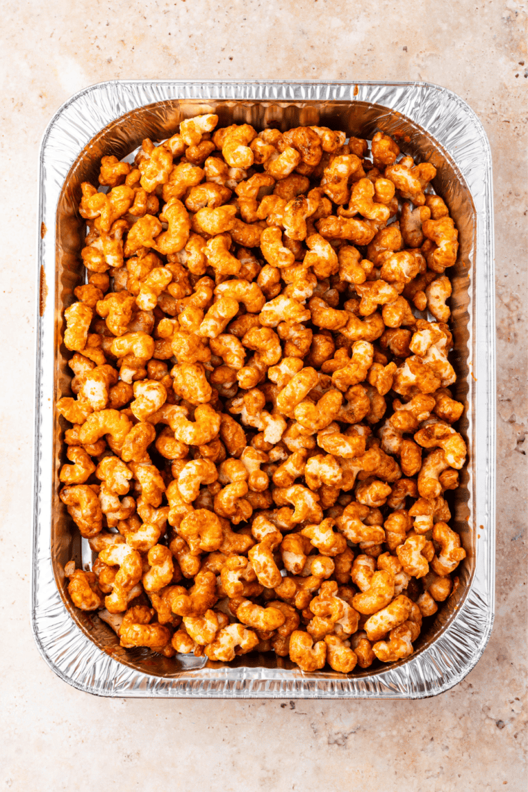 Caramel being stirred into puffed corn for homemade Buc-ee's nuggets