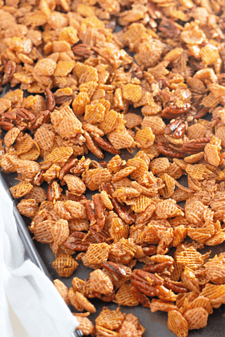 Bake low and slow: Caramel-coated Crispix snack mix spread evenly on a baking sheet, ready to bake at 250°F