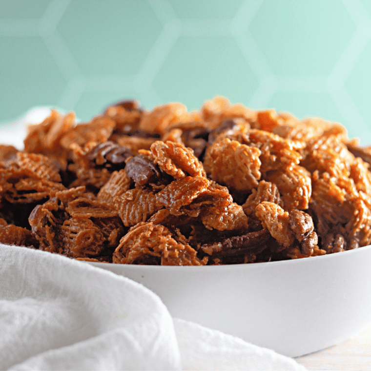 Bowl of pecan praline Crispix snack mix with glossy caramel-coated cereal and toasted pecan halves