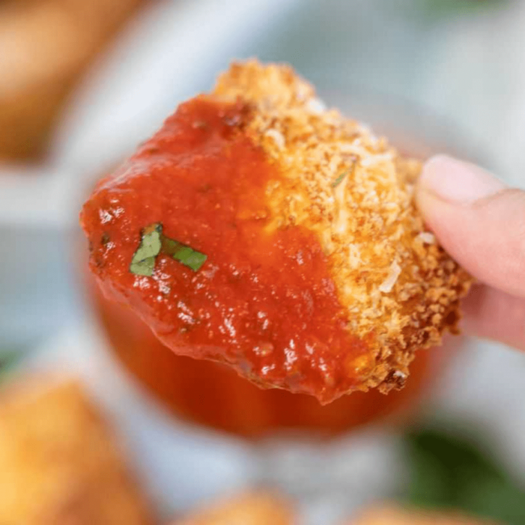 Spoonful of thick marinara dip showing the smooth, glossy texture