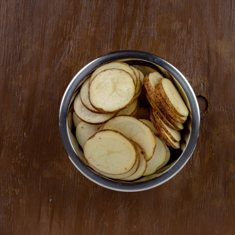 Russet potato slices cut ⅛ inch thick on a mandoline for copycat Buc-ee’s Beaver Chips
