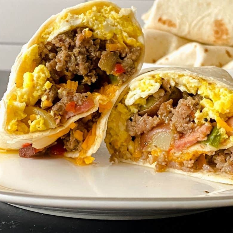 Copycat Buc-ee's breakfast burrito cut in half showing sausage, scrambled egg, and melted cheese