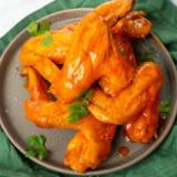 Copycat Culver’s buffalo sauce in a small white bowl next to crispy chicken tenders