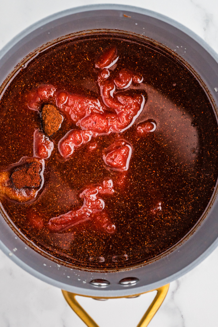 Whisking ketchup, brown sugar, molasses, and spices together in a small saucepan