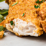 Close-up of a crispy copycat Hardee&rsquo;s chicken tender dipped in honey mustard