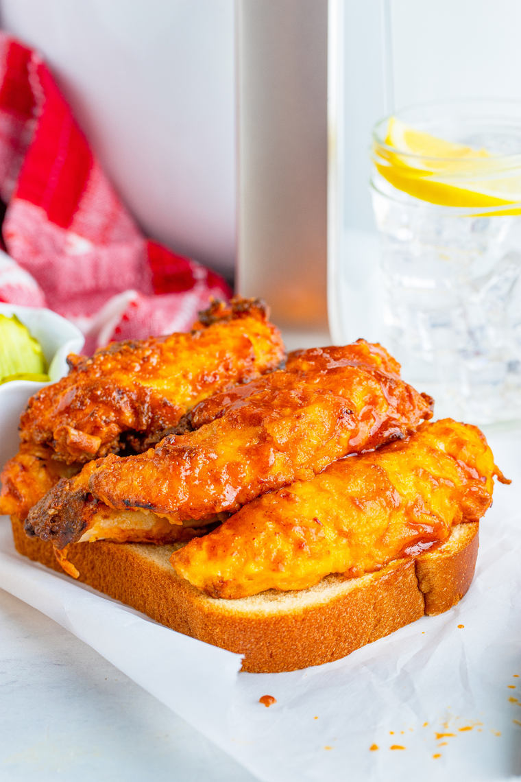 Plate of Hot Hardee&rsquo;s chicken tenders with pickle chips and buttermilk ranch