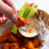 Copycat Pizza Hut boneless wings on a plate with ranch, celery, and carrot sticks.