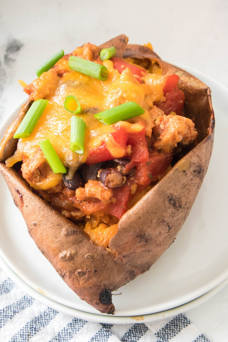 Baked sweet potato split open and stuffed with copycat Sonic chili and shredded cheddar